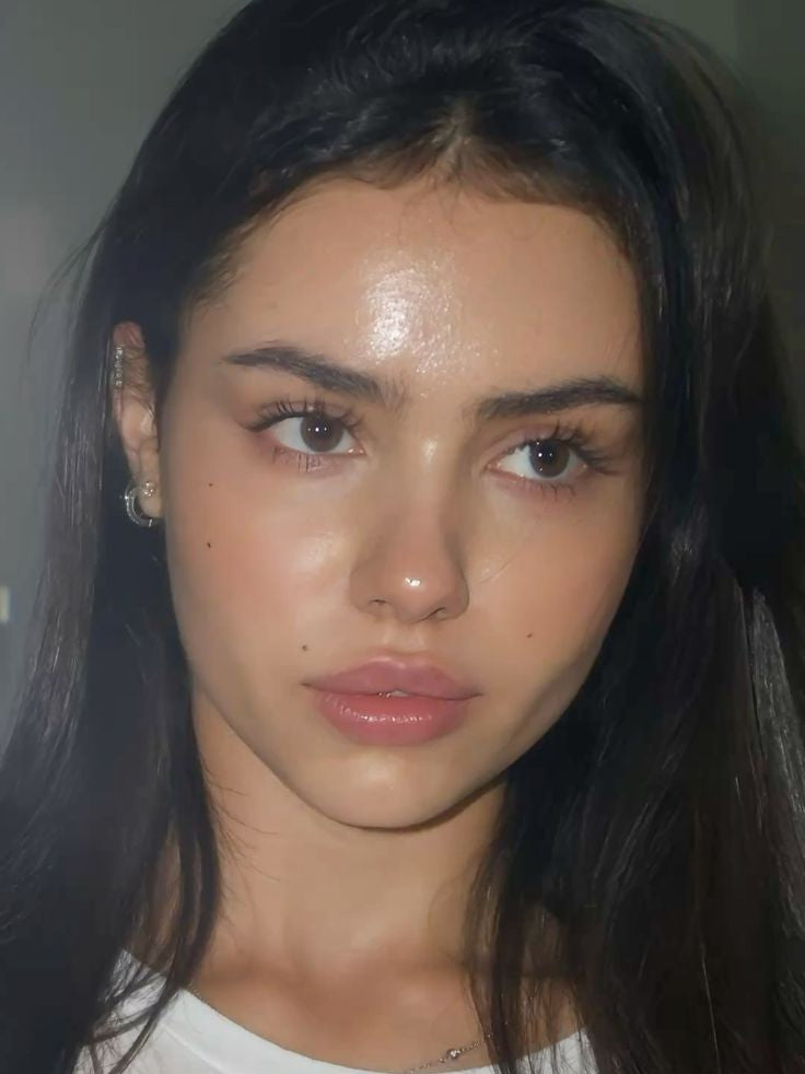 Close-up of a person with long dark hair wearing a white shirt.